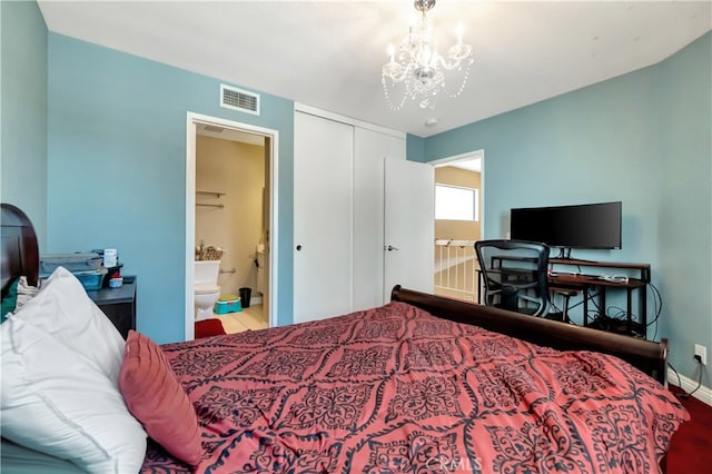 bedroom with hardwood / wood-style floors, a closet, ensuite bath, and a chandelier