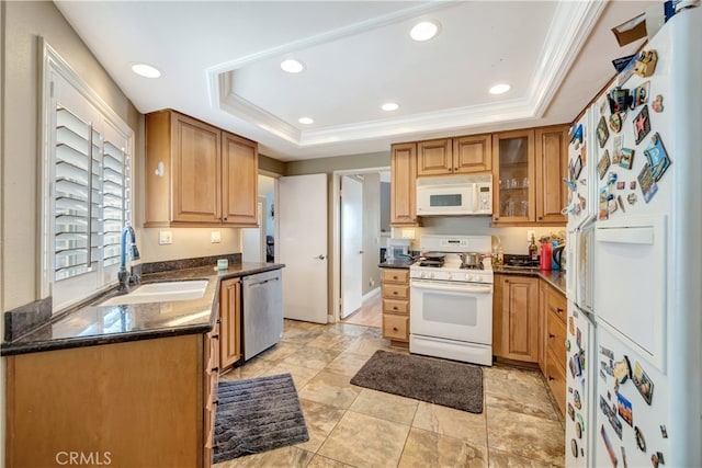 kitchen with a raised ceiling, crown molding, sink, and white appliances