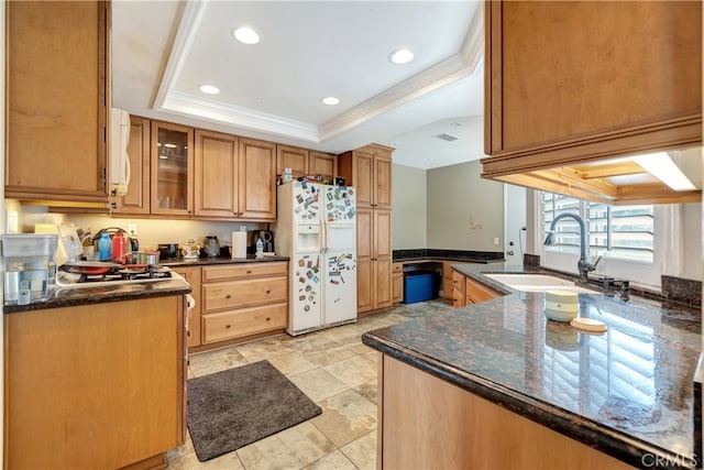 kitchen with sink, kitchen peninsula, white appliances, a raised ceiling, and ornamental molding