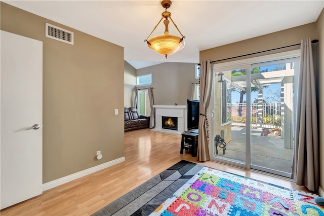 doorway to outside featuring wood-type flooring and a brick fireplace