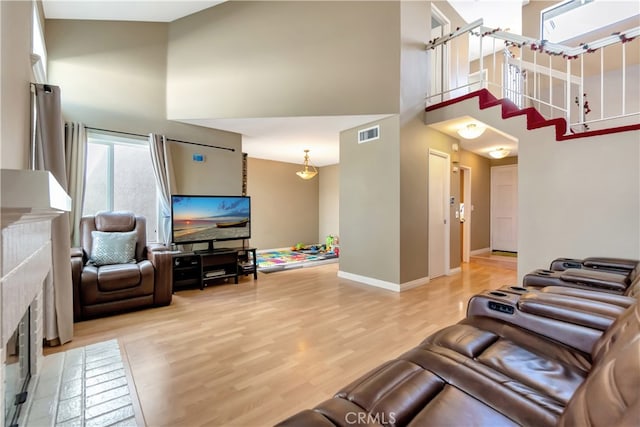 living room with a towering ceiling and wood-type flooring