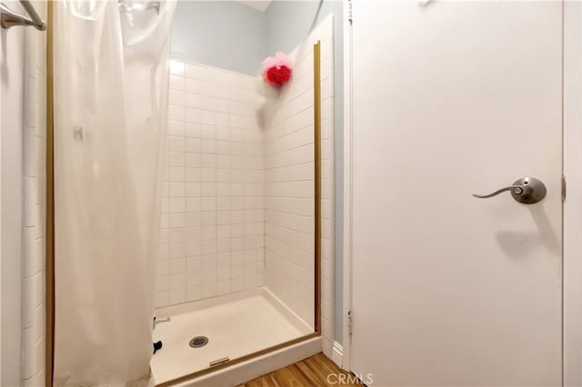 bathroom featuring a shower with shower curtain and hardwood / wood-style flooring