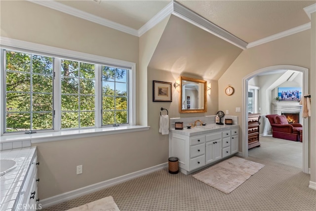 bathroom featuring vanity, crown molding, and vaulted ceiling