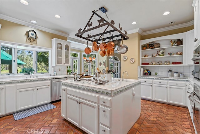 kitchen with white gas cooktop, white cabinets, backsplash, a center island, and stainless steel dishwasher