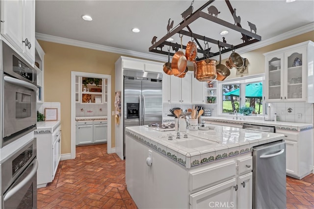 kitchen featuring backsplash, white cabinetry, crown molding, and a center island