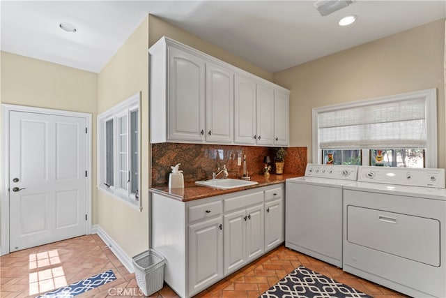 laundry area with sink, washer and dryer, and cabinets