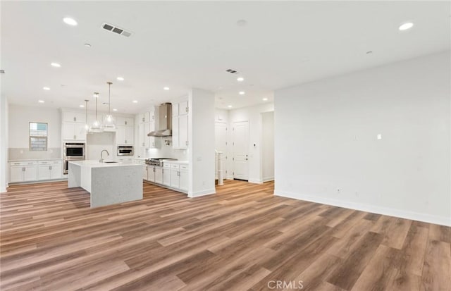 21239 W Wildflower Way, Chatsworth, CA 91311 - kitchen featuring wall chimney exhaust hood, open floor plan, appliances with stainless steel finishes, recessed lighting, and white cabinetry