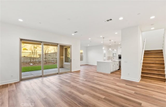 21239 W Wildflower Way, Chatsworth, CA 91311 - unfurnished living room featuring light wood finished floors, recessed lighting, and stairway