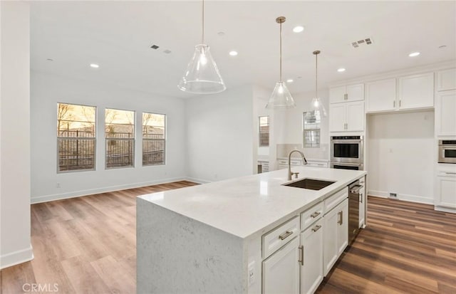 21239 W Wildflower Way, Chatsworth, CA 91311 - kitchen with recessed lighting, white cabinetry, light wood-style flooring, stainless steel dishwasher, and decorative light fixtures