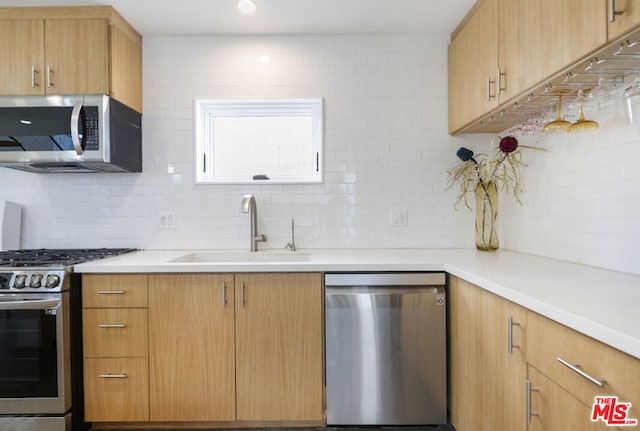 kitchen with decorative backsplash, stainless steel appliances, light brown cabinets, and sink