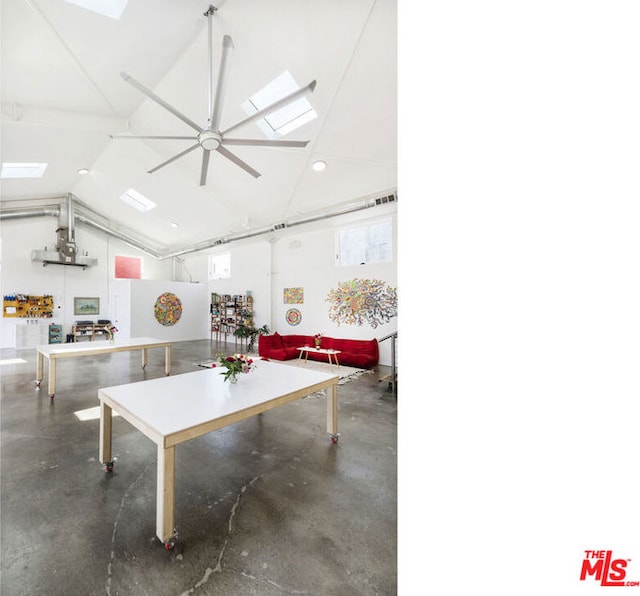 game room with vaulted ceiling with skylight, ceiling fan, and concrete floors