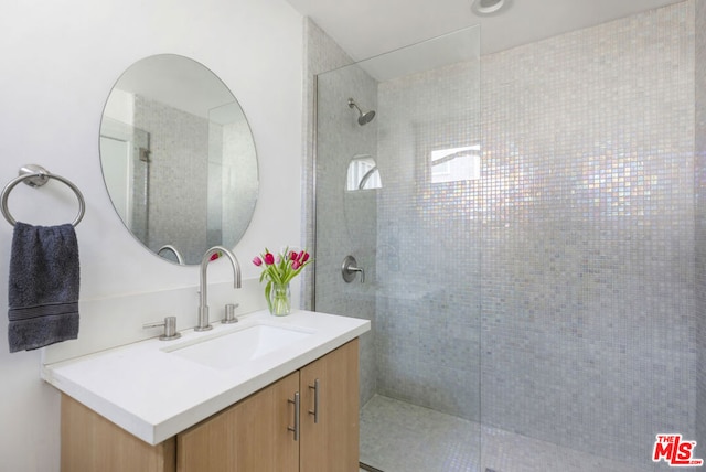 bathroom featuring a tile shower and vanity