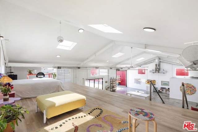 bedroom featuring hardwood / wood-style floors and lofted ceiling with skylight