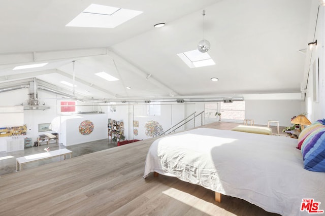 bedroom with vaulted ceiling with skylight and wood-type flooring