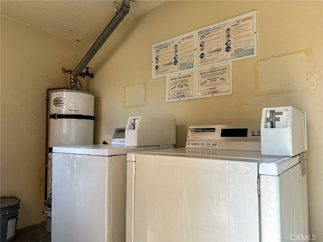 clothes washing area with separate washer and dryer, a textured ceiling, and water heater