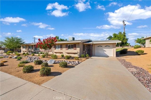 ranch-style house featuring a garage, concrete driveway, and stucco siding