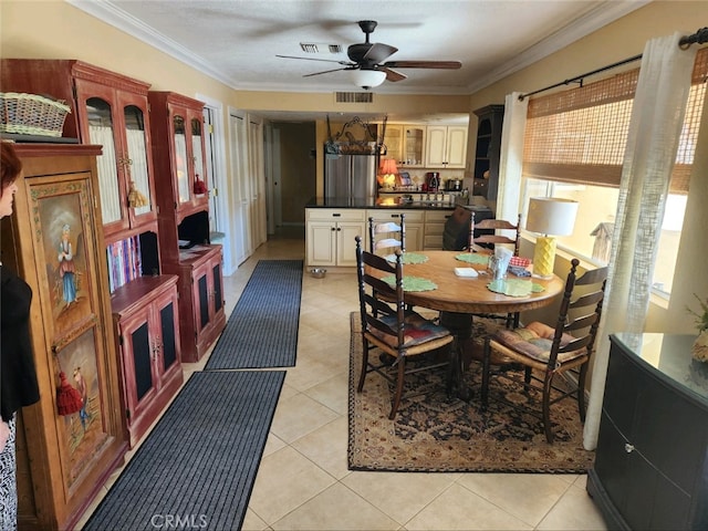 tiled dining area featuring ceiling fan and ornamental molding