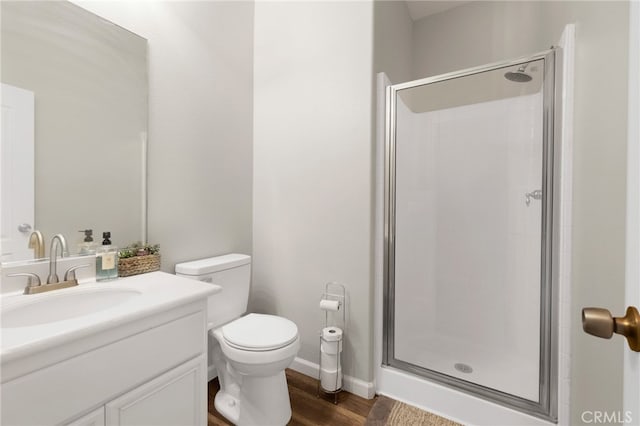 bathroom featuring wood-type flooring, vanity, toilet, and a shower with door