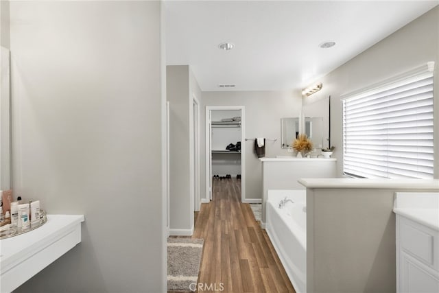 bathroom featuring hardwood / wood-style flooring, vanity, and a bathing tub