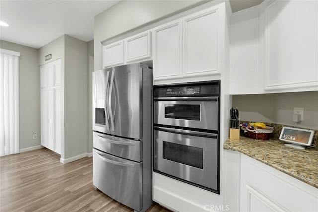 kitchen featuring light stone counters, light hardwood / wood-style floors, stainless steel appliances, and white cabinets