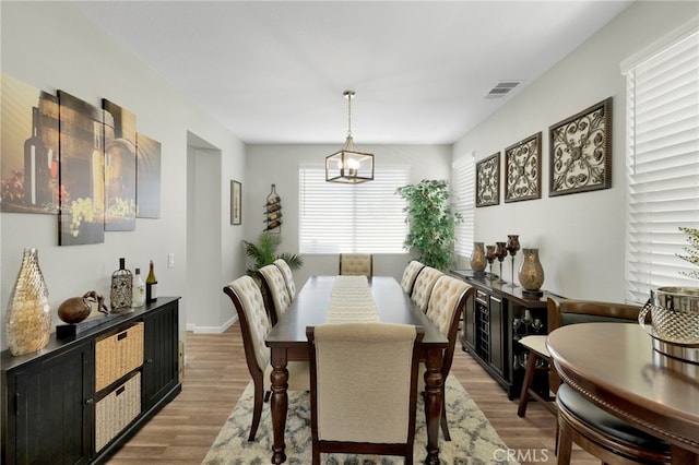 dining area with an inviting chandelier and wood-type flooring