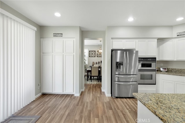 kitchen featuring light hardwood / wood-style flooring, white cabinetry, stainless steel appliances, a notable chandelier, and light stone countertops