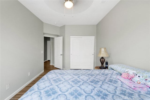 bedroom with a closet, ceiling fan, and dark hardwood / wood-style flooring