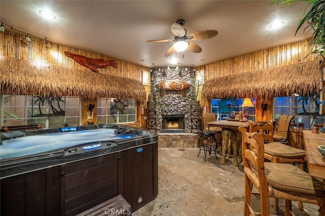 interior space featuring a fireplace, dark brown cabinets, and ceiling fan