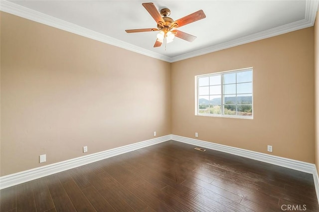 empty room featuring ornamental molding, ceiling fan, and dark wood-type flooring