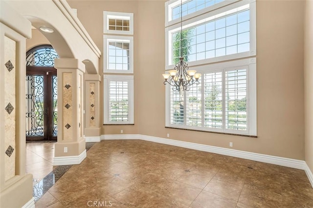 foyer featuring a healthy amount of sunlight, a high ceiling, and a chandelier