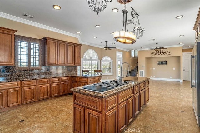 kitchen featuring an island with sink, a wealth of natural light, and tasteful backsplash