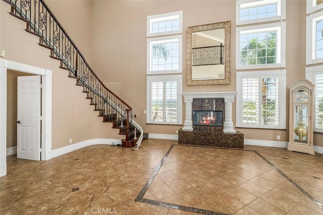 foyer entrance featuring a wealth of natural light, a high end fireplace, and a high ceiling