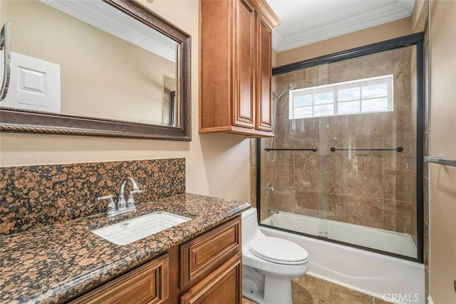 full bathroom with vanity, crown molding, bath / shower combo with glass door, tile patterned flooring, and toilet