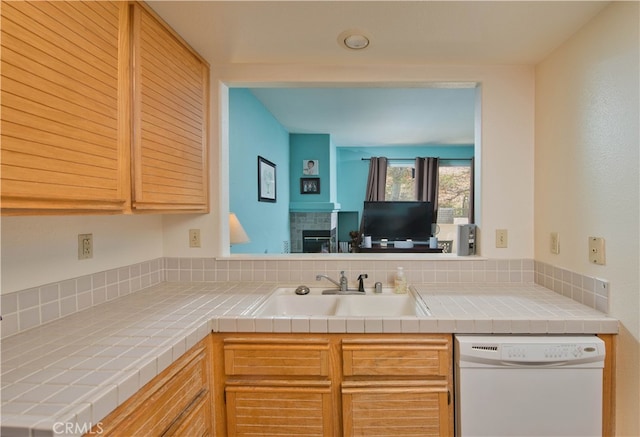 kitchen featuring white dishwasher, tile counters, tasteful backsplash, and sink