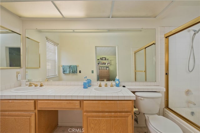 full bathroom featuring shower / bath combination with glass door, vanity, and toilet