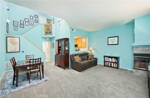 living room with a stone fireplace and light carpet