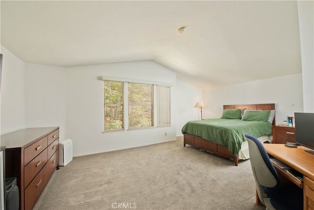 bedroom with lofted ceiling and light colored carpet