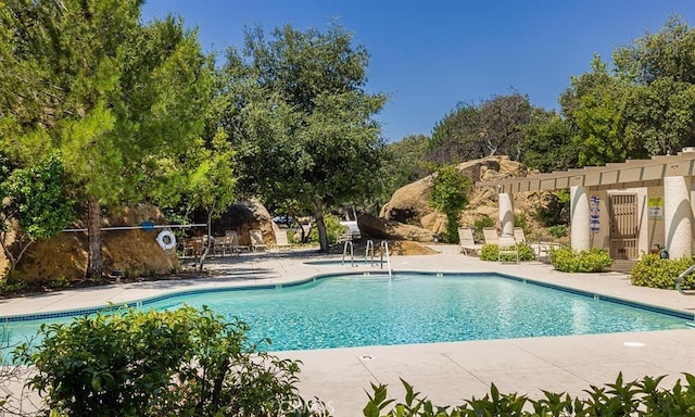 community pool with a patio area and a pergola