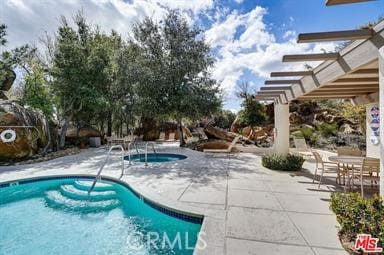 view of swimming pool featuring a patio and a hot tub