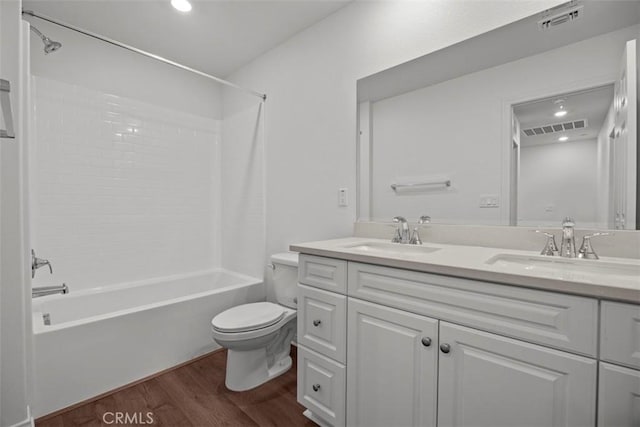 full bathroom featuring toilet, wood-type flooring, vanity, and bathing tub / shower combination