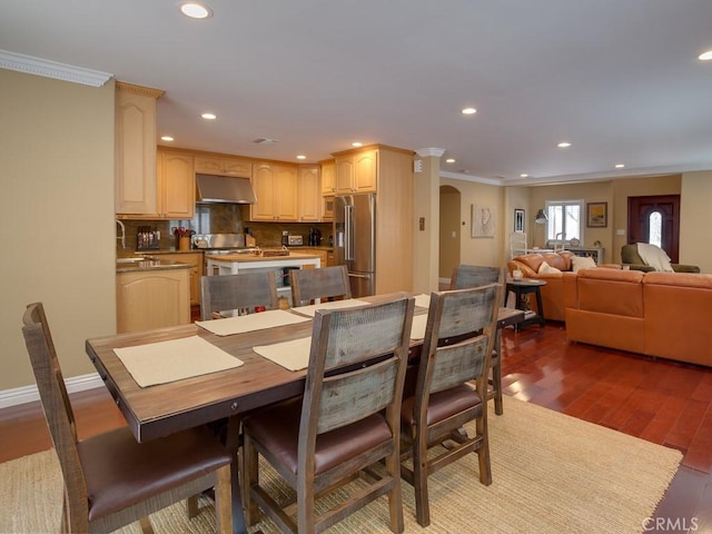 dining room with dark hardwood / wood-style flooring and crown molding