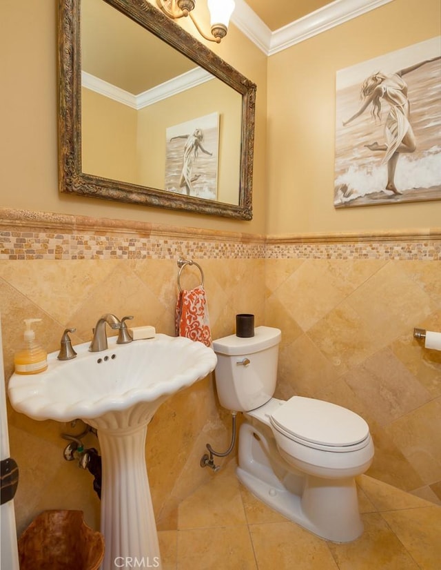 bathroom featuring tile patterned floors, toilet, tile walls, and ornamental molding