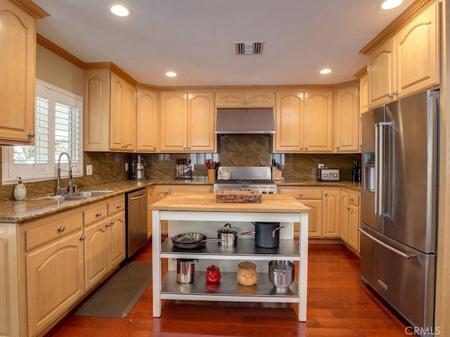 kitchen featuring sink, stainless steel appliances, tasteful backsplash, dark hardwood / wood-style flooring, and light brown cabinetry