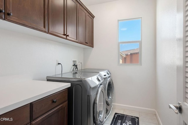 clothes washing area featuring cabinets, light tile patterned floors, and separate washer and dryer