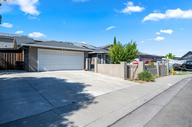 view of front of property featuring a garage and solar panels