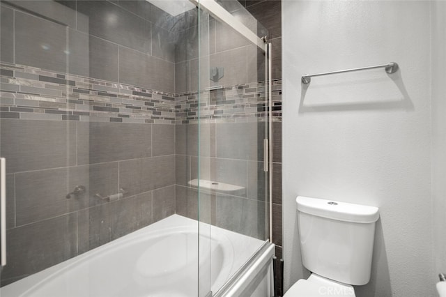 bathroom with shower / bath combination with glass door and toilet