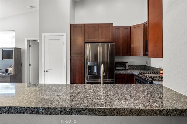 kitchen with appliances with stainless steel finishes, kitchen peninsula, and vaulted ceiling