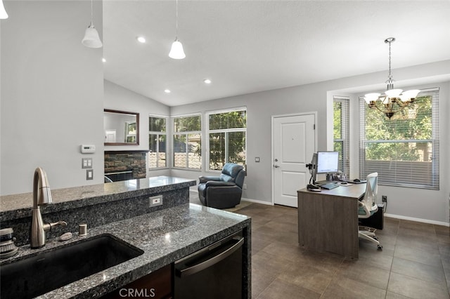 kitchen with lofted ceiling, a stone fireplace, sink, and decorative light fixtures