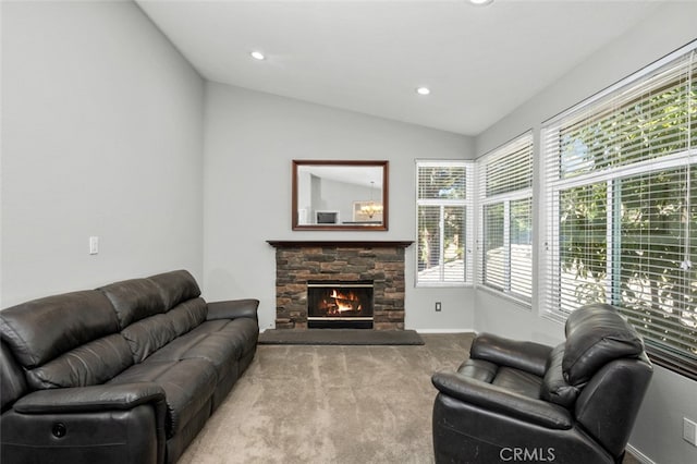 living room with a stone fireplace, lofted ceiling, and light carpet