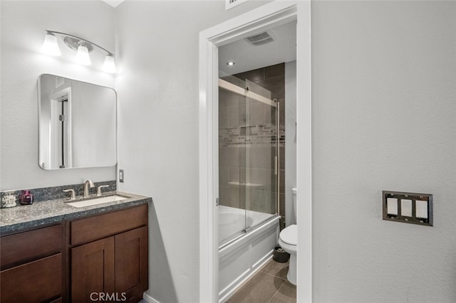 full bathroom with shower / bath combination with glass door, vanity, toilet, and tile patterned floors